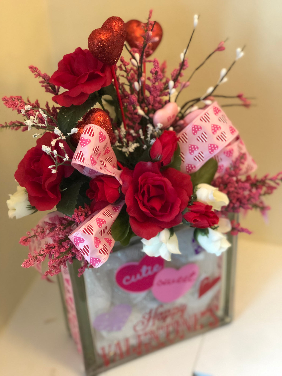 Valentine arrangement of red roses, glitter heart picks and pink heart ribbon on the glass block