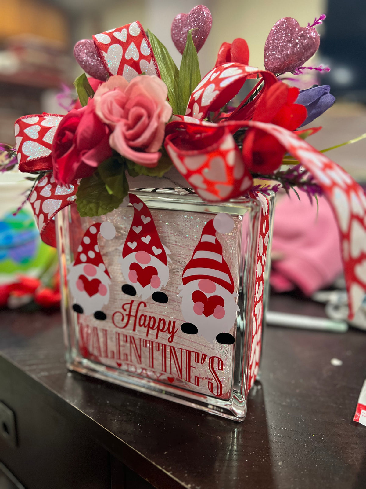 Side view of the gnome Valentine's glass block and floral topper