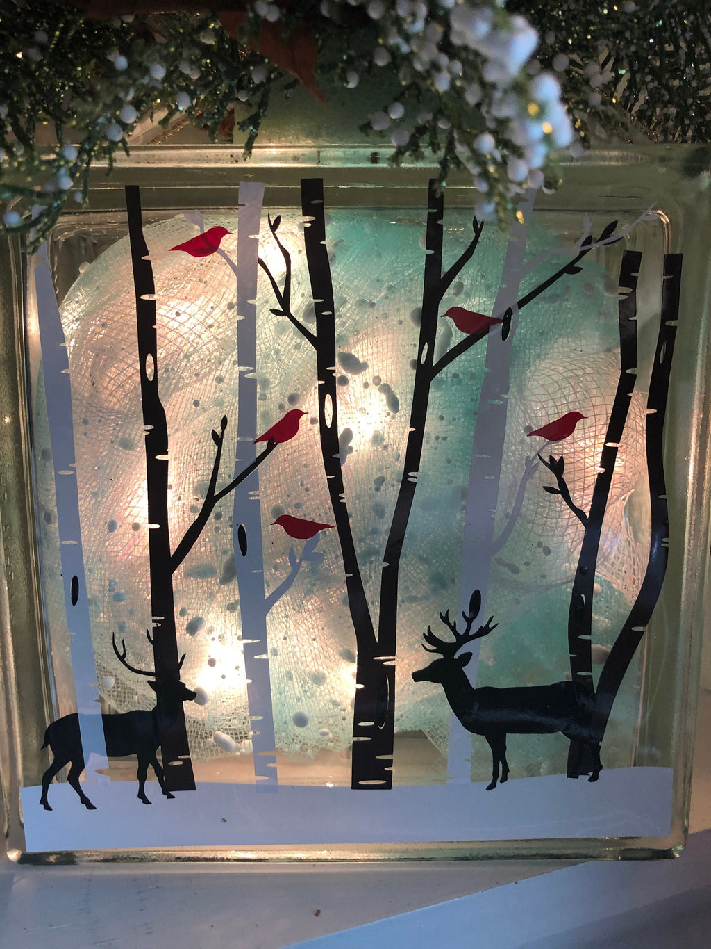 Close-up of glowing birch trees, red cardinals and deer silhouettes