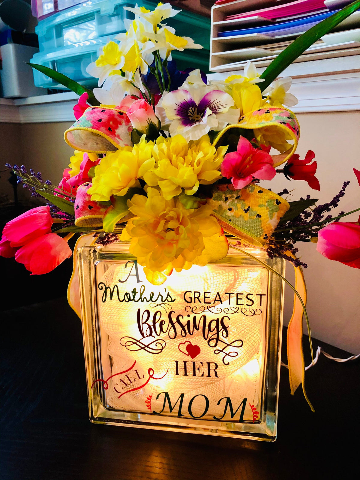 Mother's Day glass block reading A Mother's Greatest Blessings Call Her Mom, with spring flowers on top